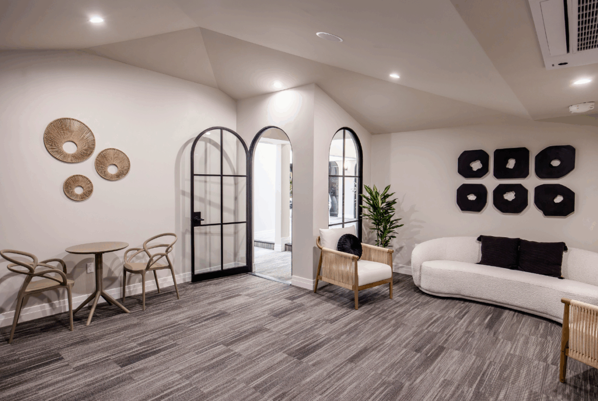 Chic salon waiting area featuring comfortable chairs, sofa, and modern wall art.