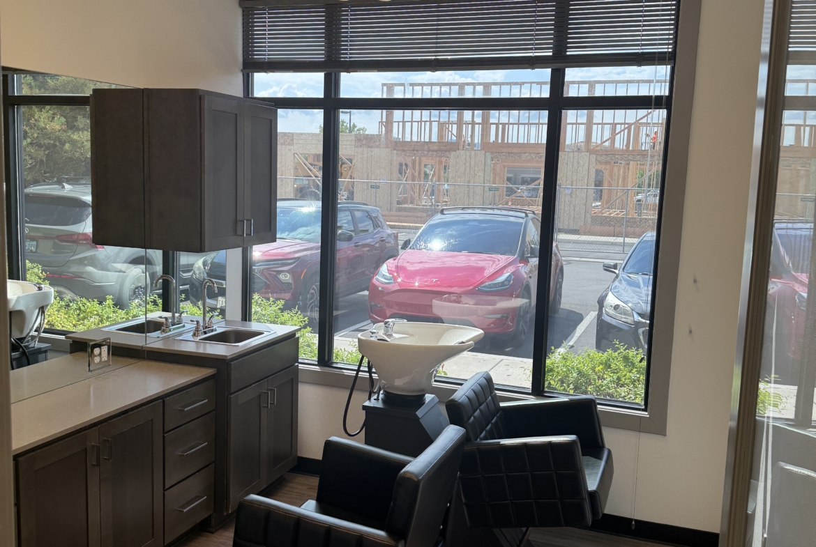 Bright salon station with modern chairs and large window, perfect for hair styling and beauty services.