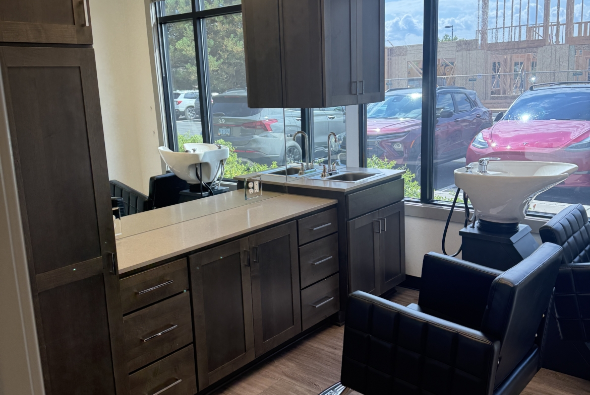 Professional salon interior with styling chairs, washbasins, and cabinetry.