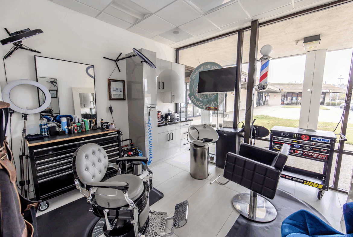 Bright barbershop with styling chairs, tools, and large window for natural light.