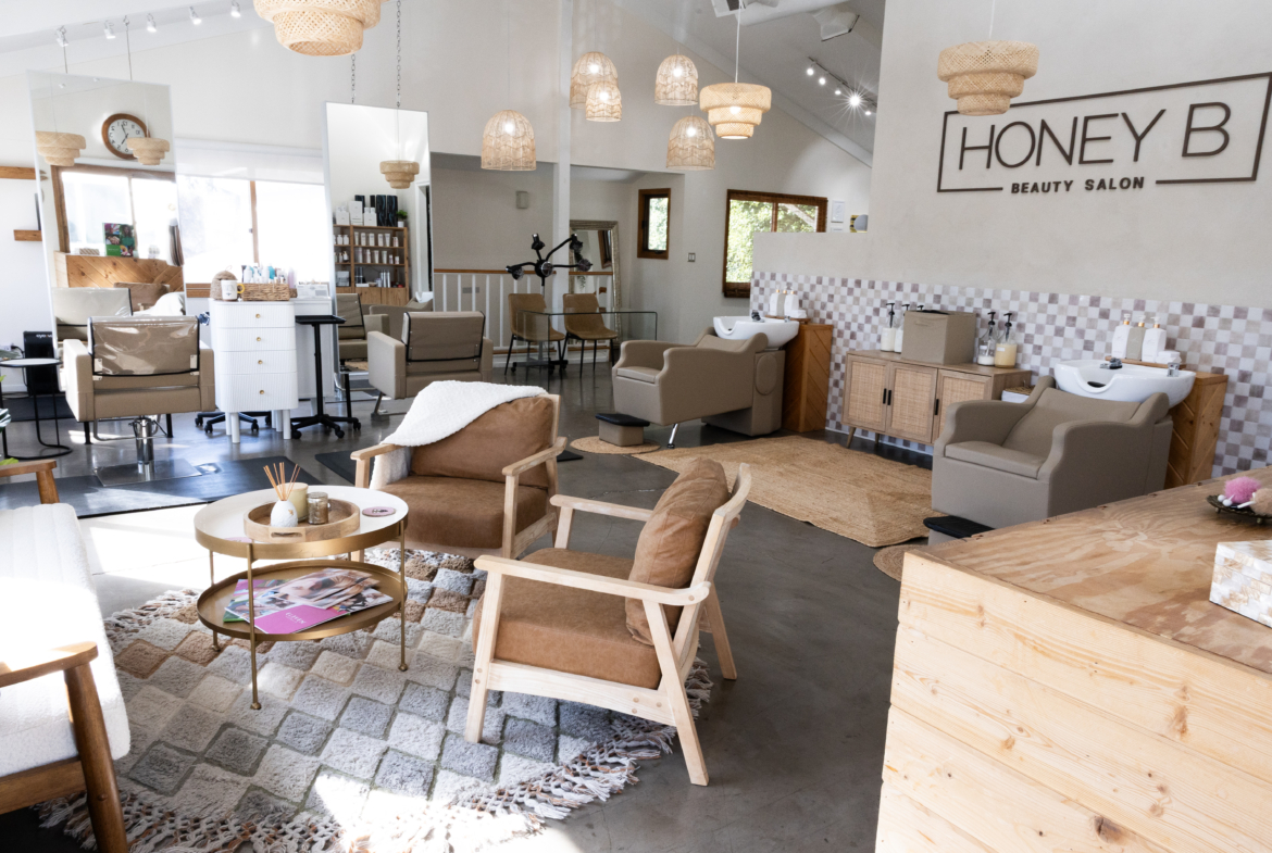 Bright, stylish beauty salon with modern chairs, washbasins, and cozy consultation areas.