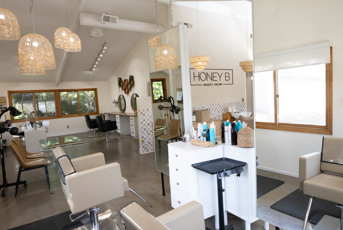 Elegant salon interior with white walls, wooden accents, and stylish lighting fixtures.