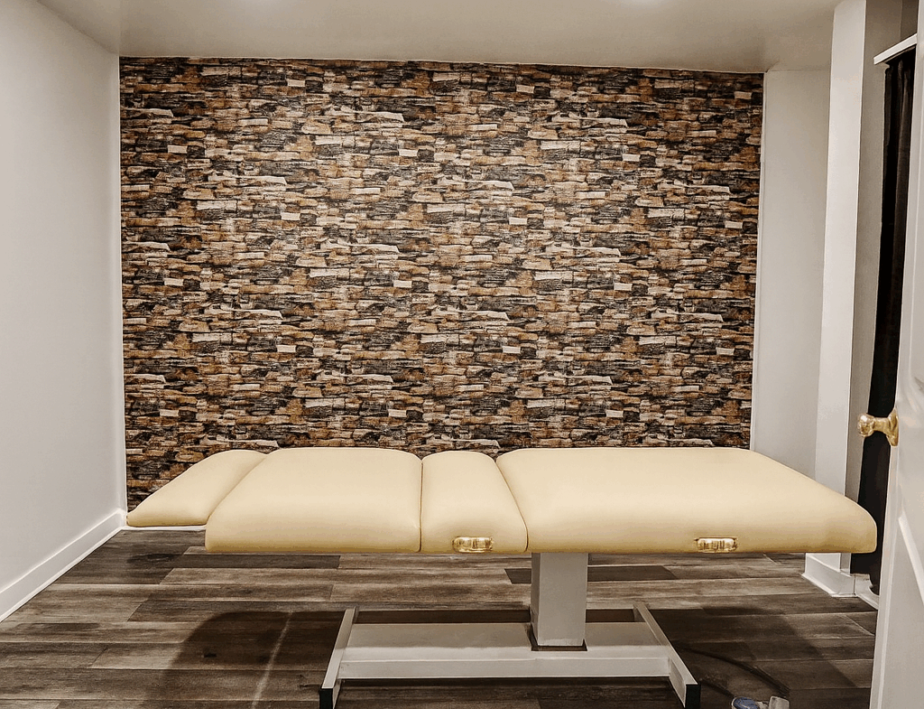 Clean massage table in a stylish salon with brick accent wall for relaxing treatments.