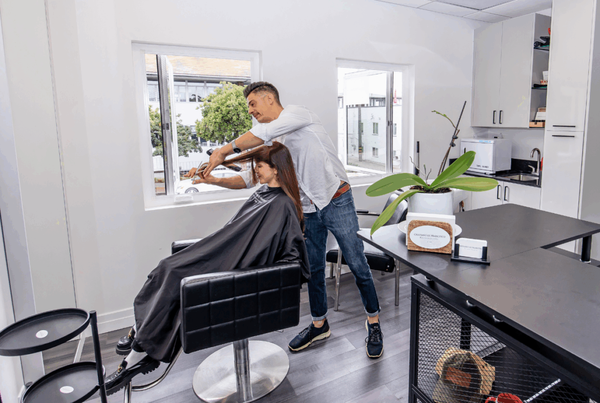 Professional hair salon interior with a stylist working on a client’s hair, natural light.