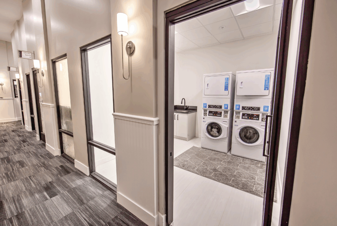 Clean salon space with laundry area for staff and clients, featuring washers and dryers for convenience.