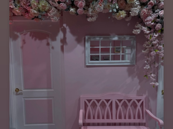 Beautiful pink-themed salon with a floral ceiling and cozy seating area.