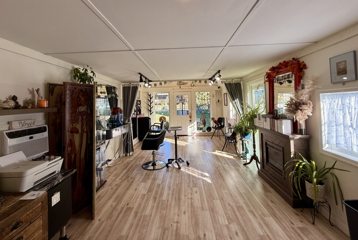 Bright salon space featuring styling chairs, decor, and large windows for renting beauty professionals.