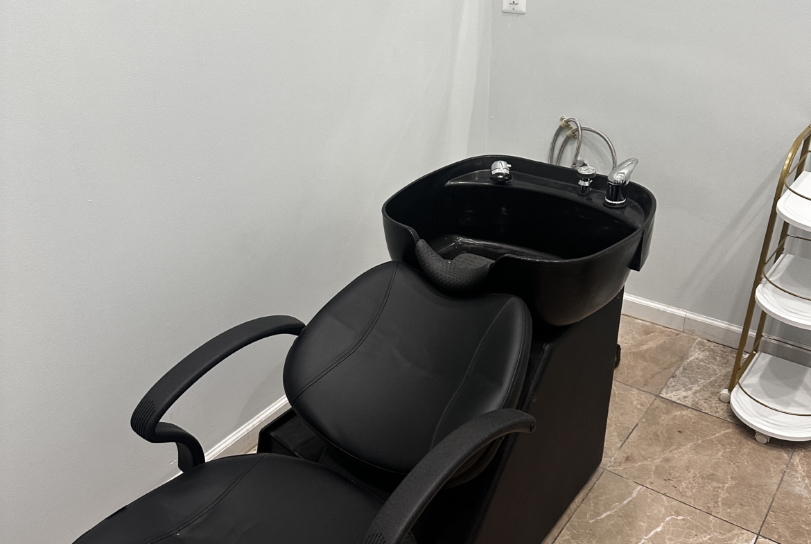 Salon wash sink with salon chair for hair washing and scalp treatments.