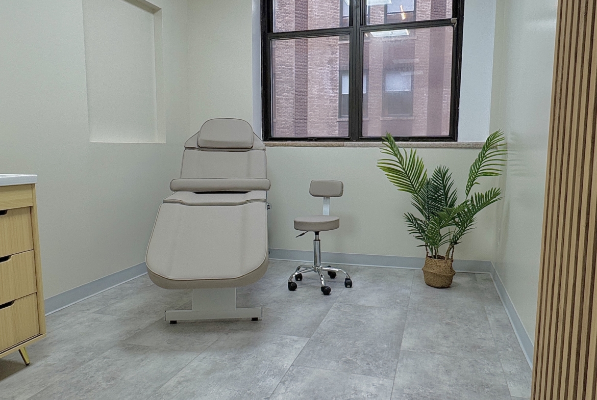 Bright salon space featuring medical-style chair, large window, and calming decor.