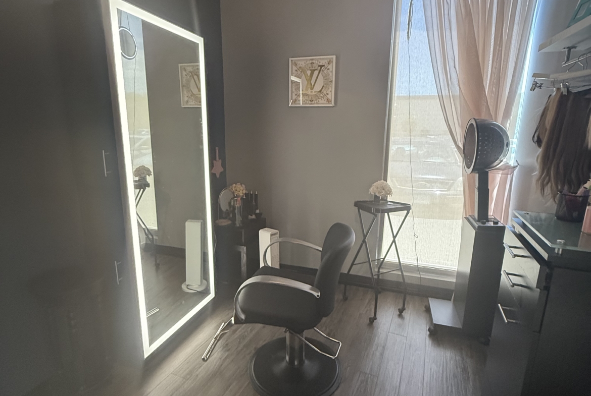 Stylish salon station with LED mirror, professional chair, and hair care tools in a cozy setting.