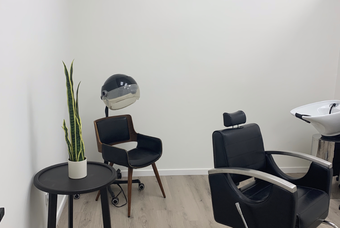 Salon rental space featuring a sleek styling chair and washing station, perfect for independent beauty entrepreneurs.