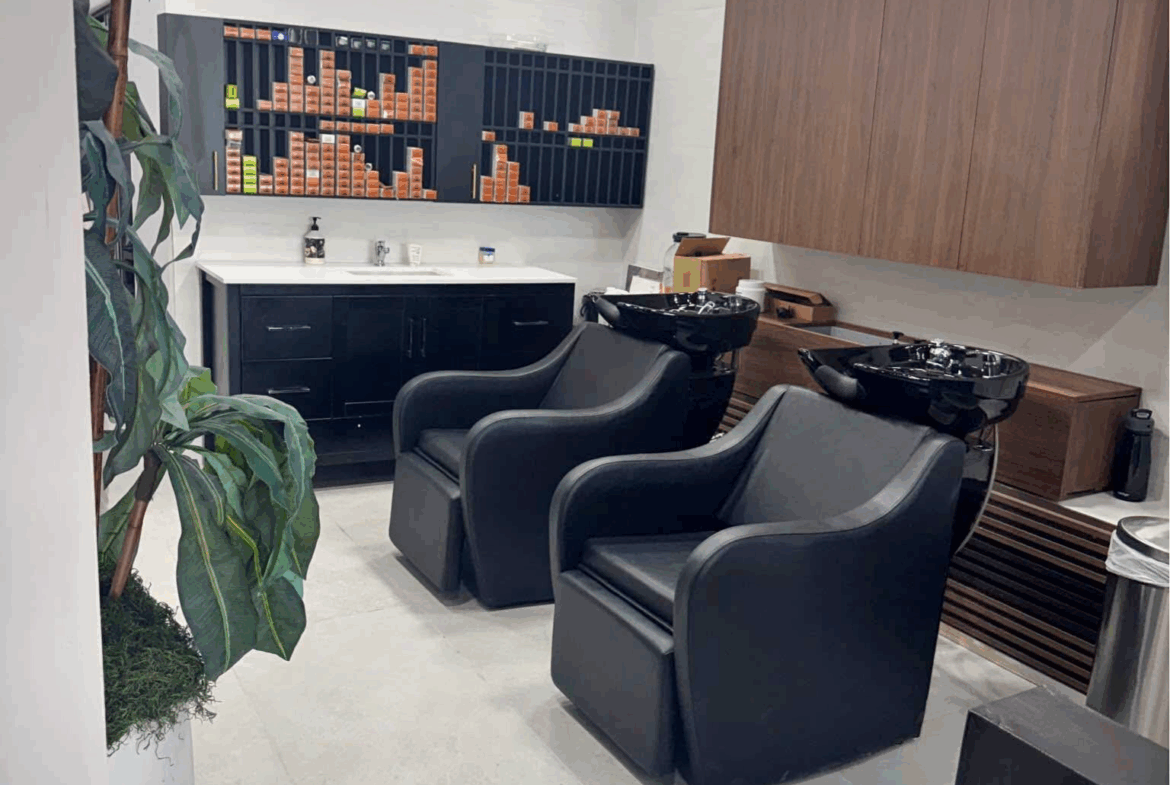Stylish salon with black chairs, shampoo station, and organized storage for rent or leasing.