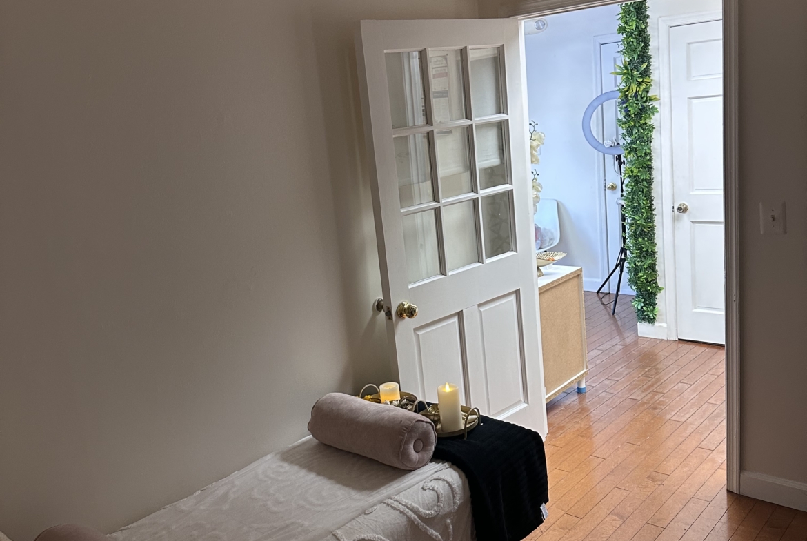 Peaceful salon studio with massage table, candles, and soft lighting for clients.