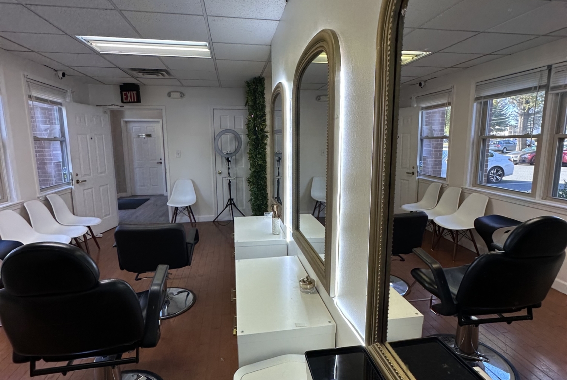 Stylish salon rental space featuring chairs, mirrors, and ample natural light for beauty professionals.
