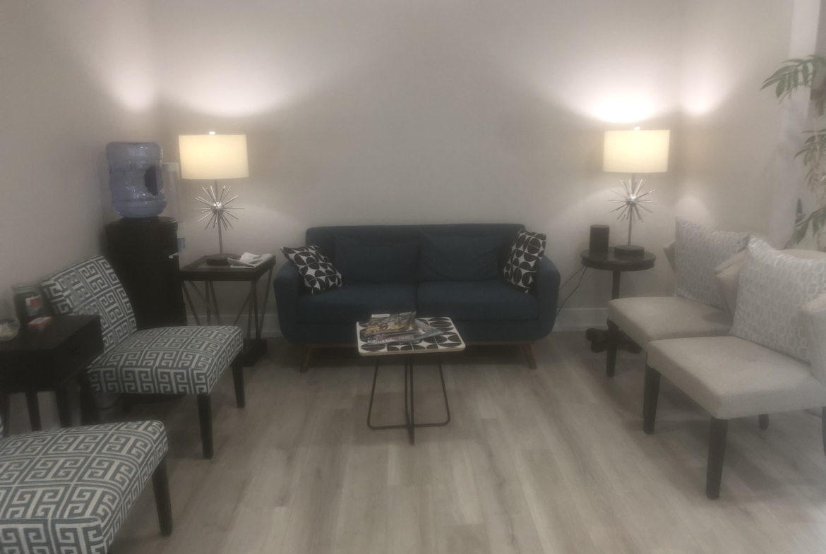 Comfortable salon waiting room featuring stylish furniture and ambient lighting.