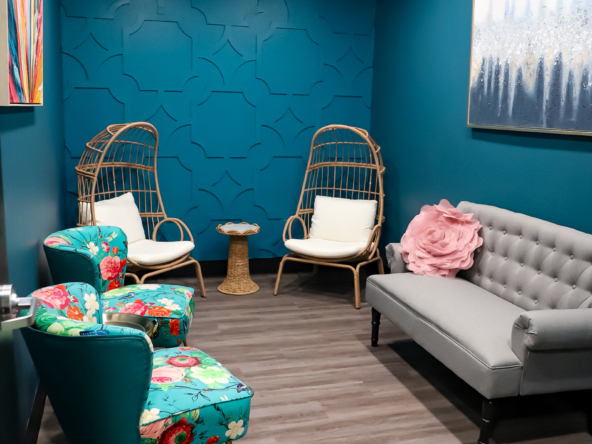 Cozy salon lounge with colorful chairs and calming blue walls.
