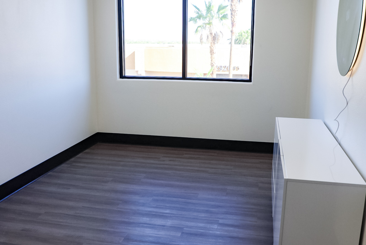 Bright, vacant salon space with natural light and modern flooring for rent.