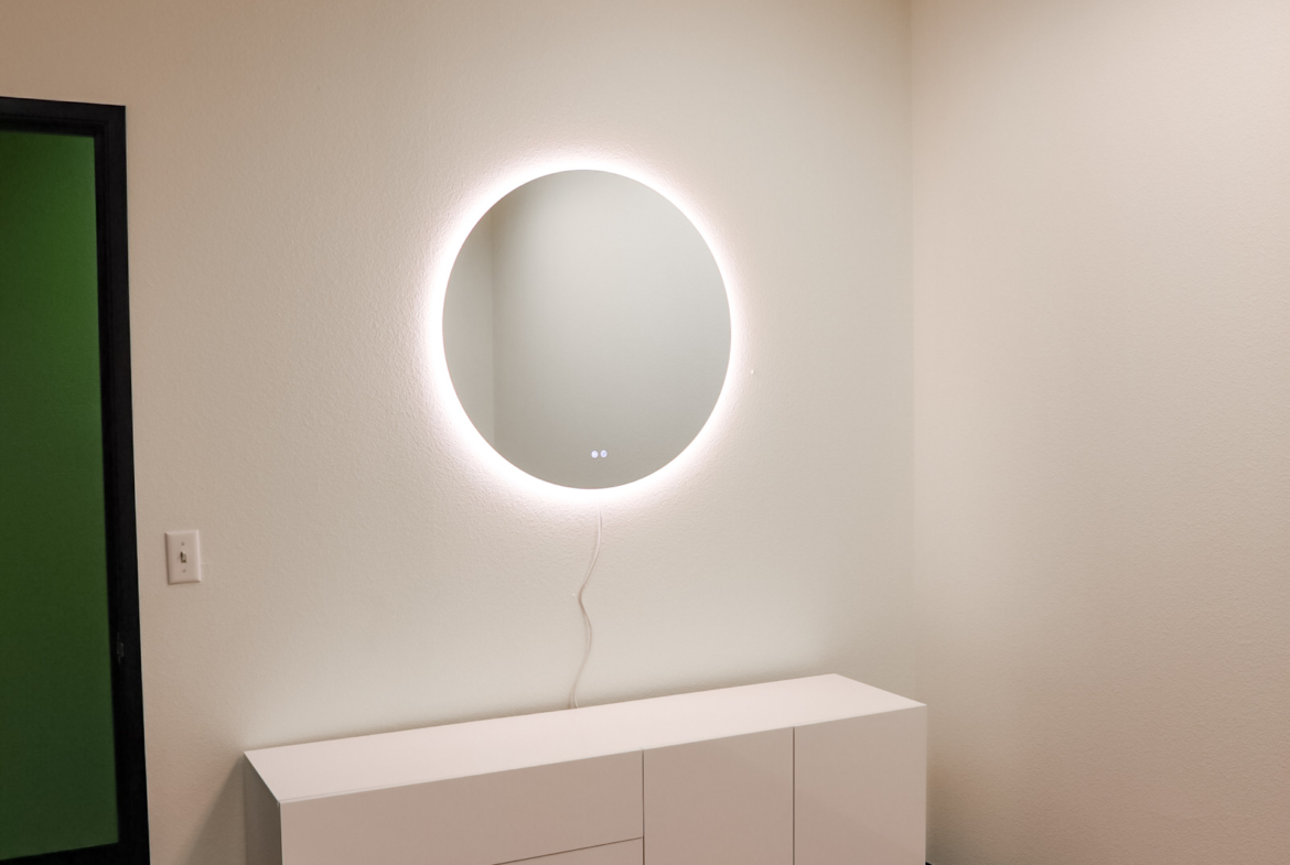 Bright LED mirror with modern white console in salon decor.