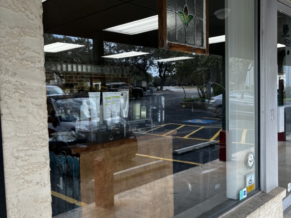 High-quality image of salon space rental storefront with large glass window, showing interior lighting and parking availability.