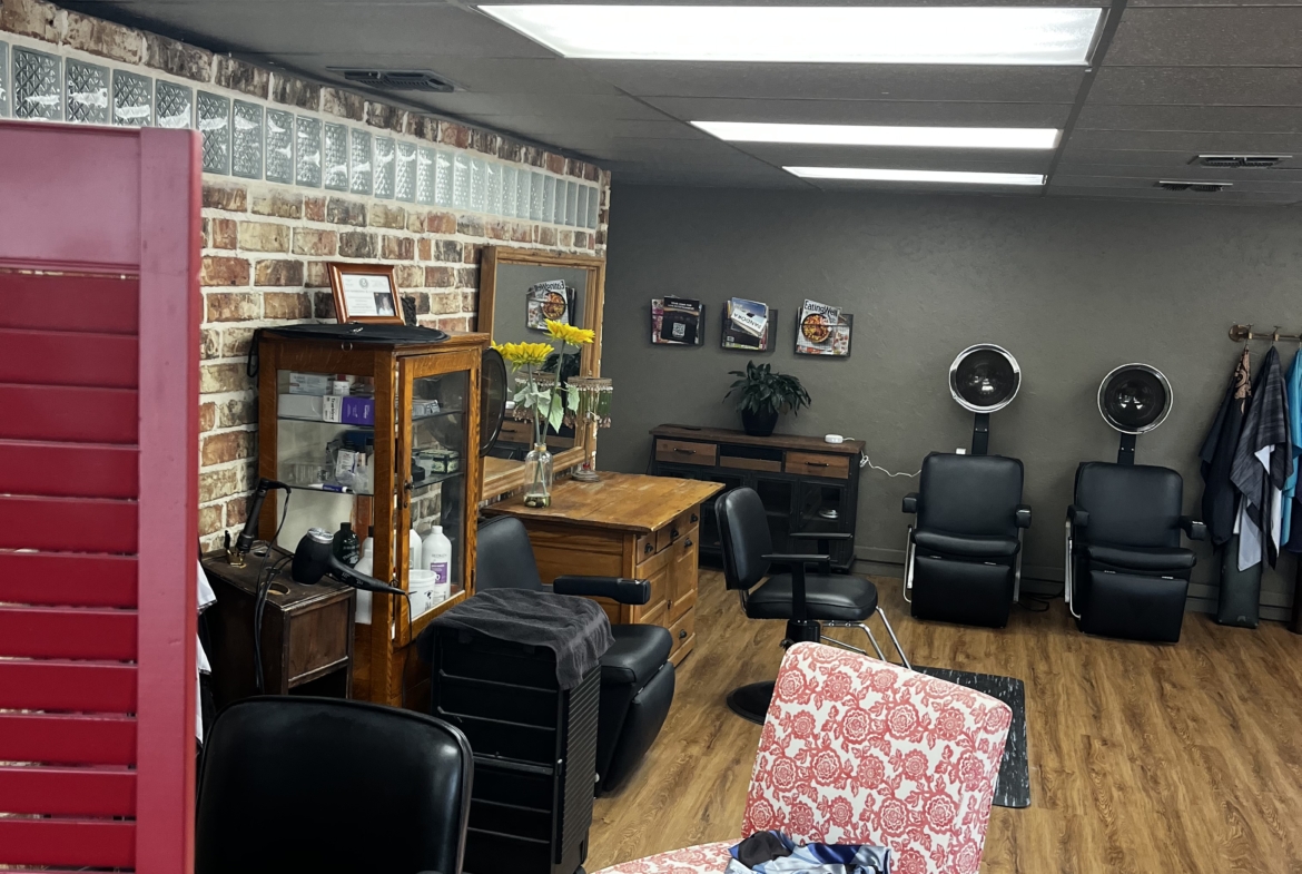 Bright salon with professional chairs, hair dryers, and styling stations.