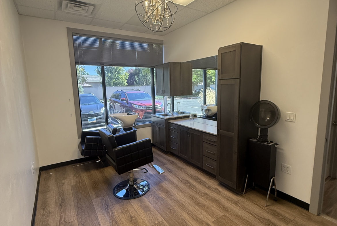Stylish salon suite with wooden floors, modern decor, and large window views.