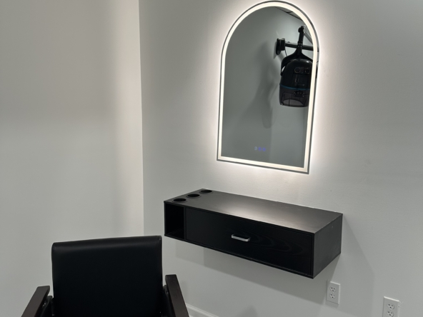 Bright, sleek salon station with mirror and chair for hair styling and beauty treatments.