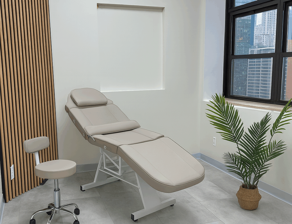 Comfortable salon treatment bed in a bright room with city views and natural decor elements.