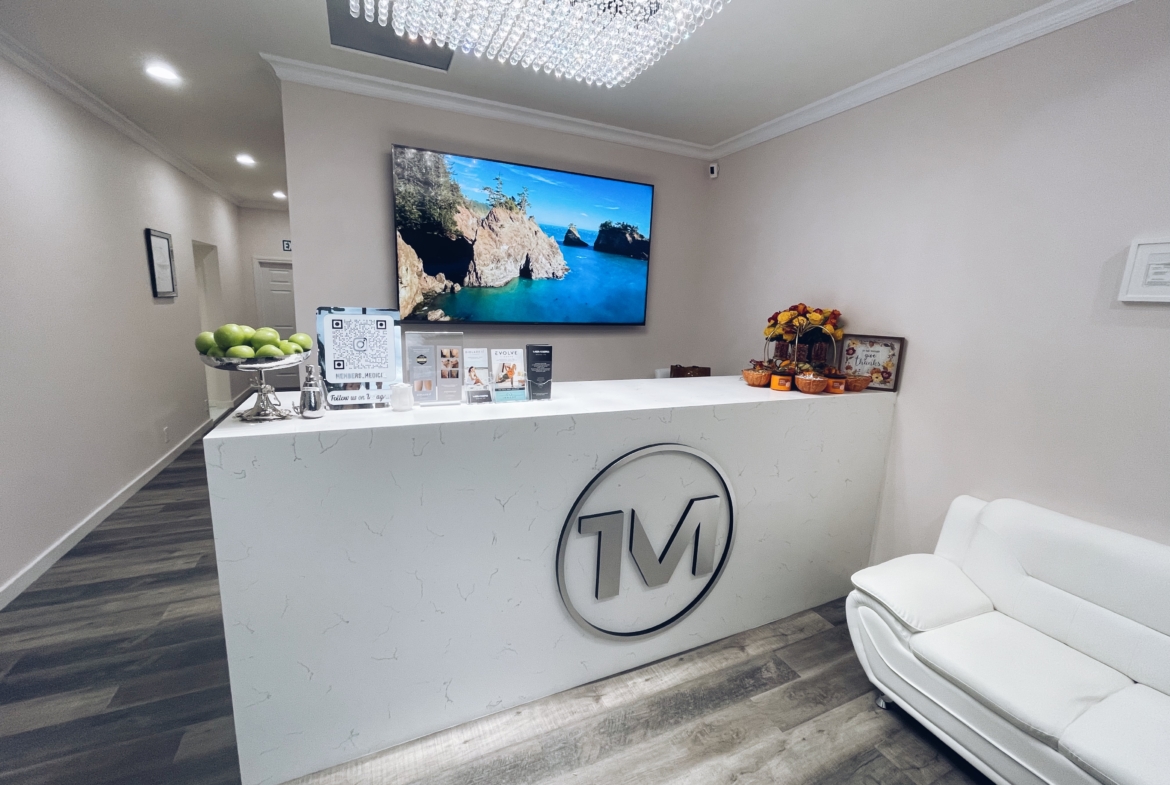 Elegant salon front desk with a large wall-mounted screen and contemporary design.