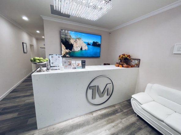 Elegant salon front desk with a large wall-mounted screen and contemporary design.