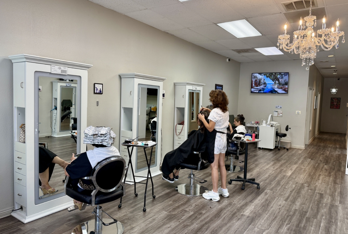 Bright salon with individual stations and mirrors for rent by hair and beauty professionals.