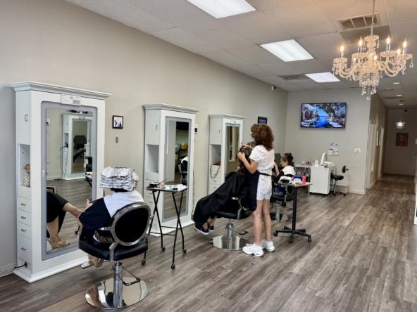 Bright salon with individual stations and mirrors for rent by hair and beauty professionals.