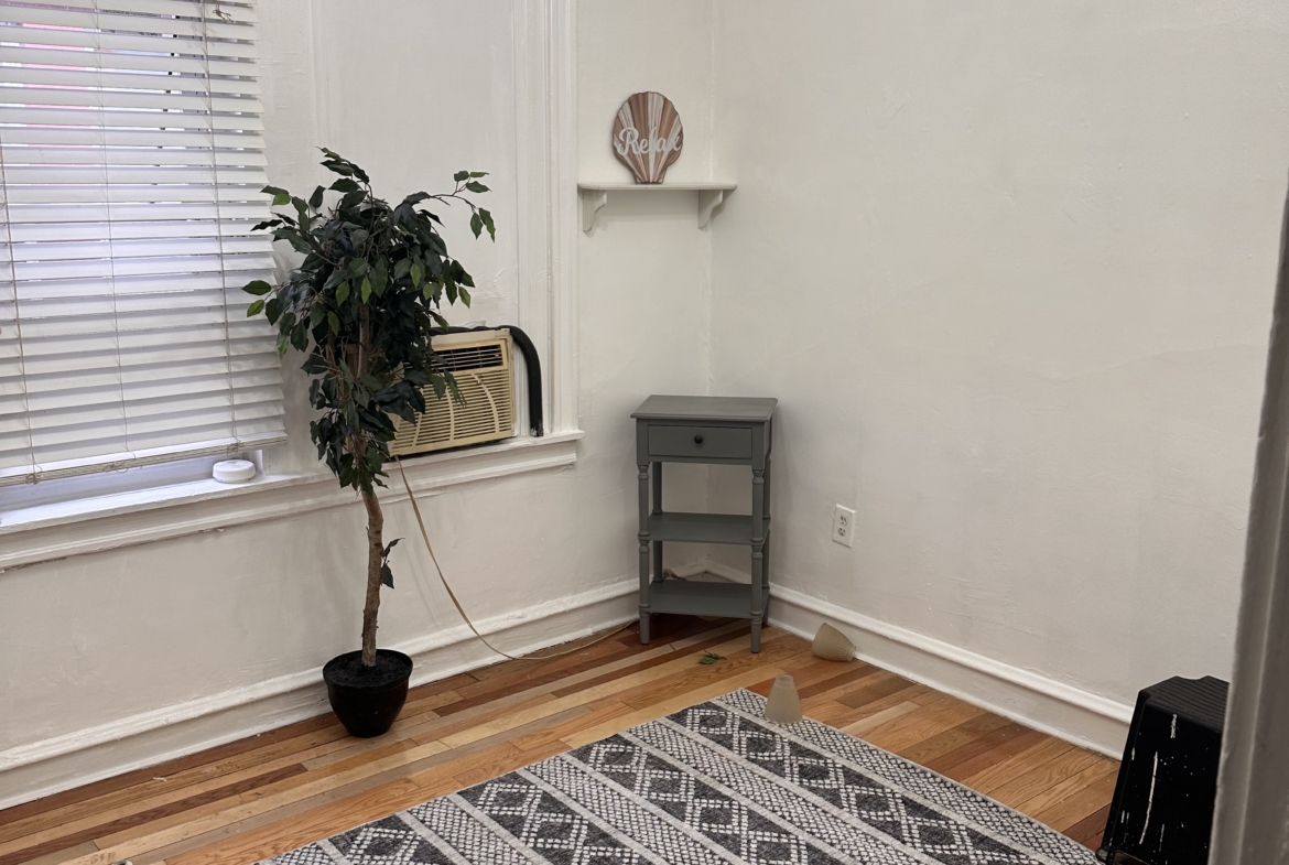 Bright interior of a salon room with a large window, modern chandelier, and minimalist décor. Perfect for renting or styling.