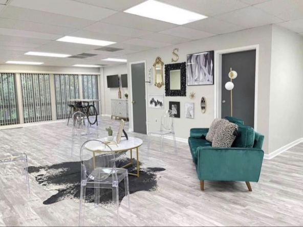 Stylish salon lounge with contemporary decor, transparent chairs, and cozy seating for clients.