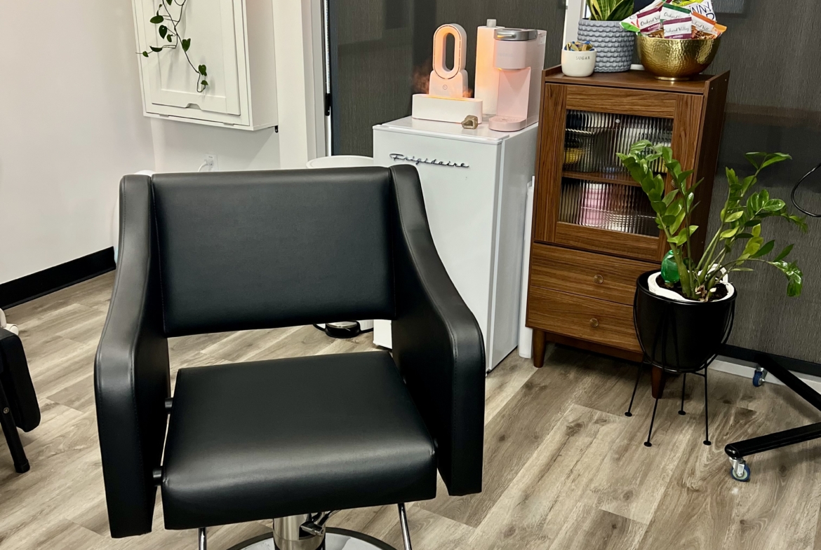 Comfortable black salon chair in trendy salon interior with plants and stylish decor.