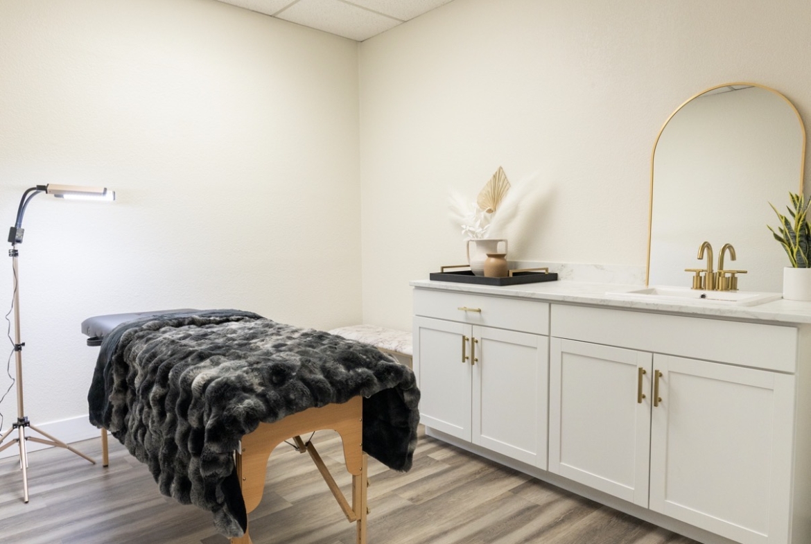 Relaxing salon massage room featuring treatment table and modern decor setup.