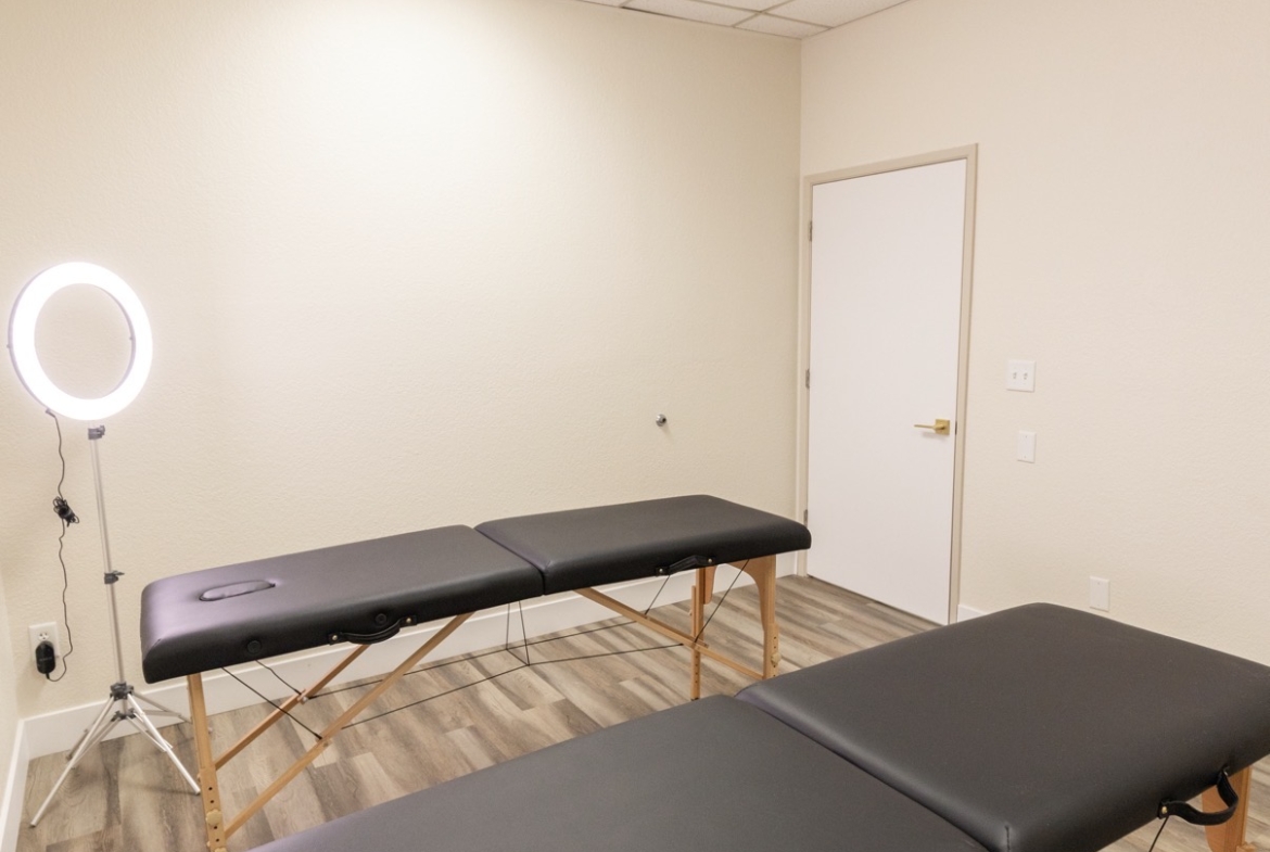 Comfortable salon massage room with treatment beds and professional lighting for client services.