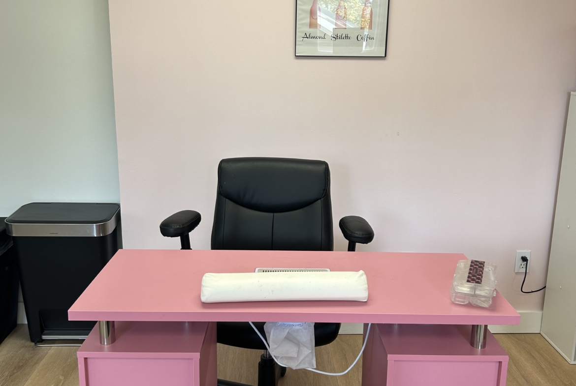 Modern salon renter office space with pink desk and black chairs for beauty professionals.