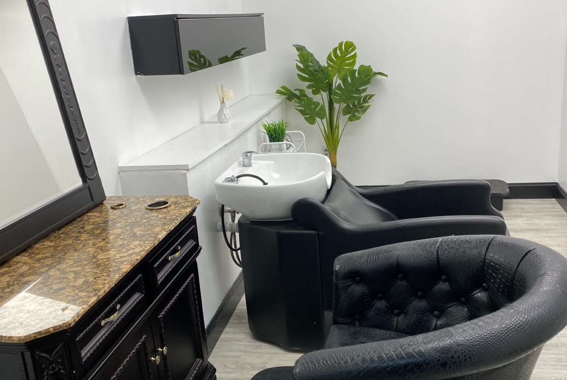 Clean salon space with styling station, shampoo bowl, and modern decor.