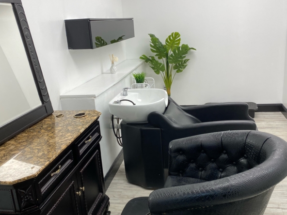 Clean salon space with styling station, shampoo bowl, and modern decor.