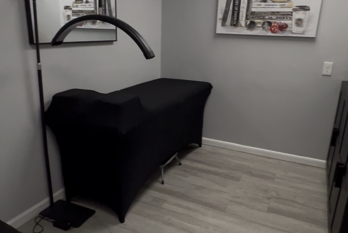 Comfortable salon treatment room with massage table, contemporary artwork, and relaxing atmosphere.