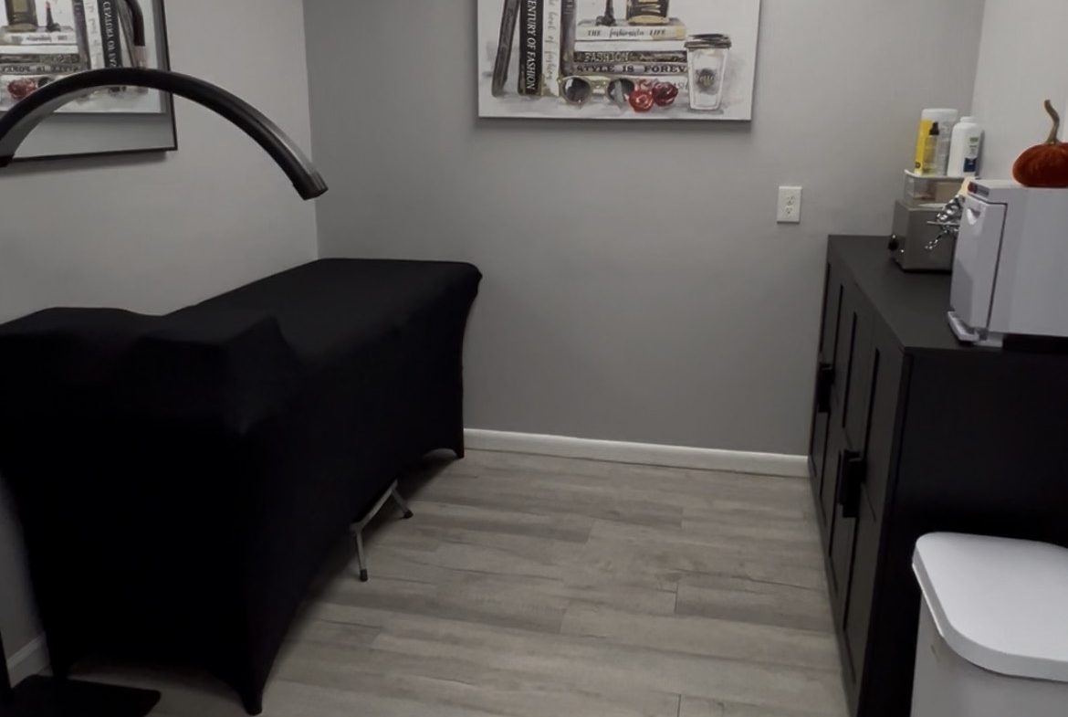 Modern salon rental room with black furniture and stylish decor for beauty professionals.