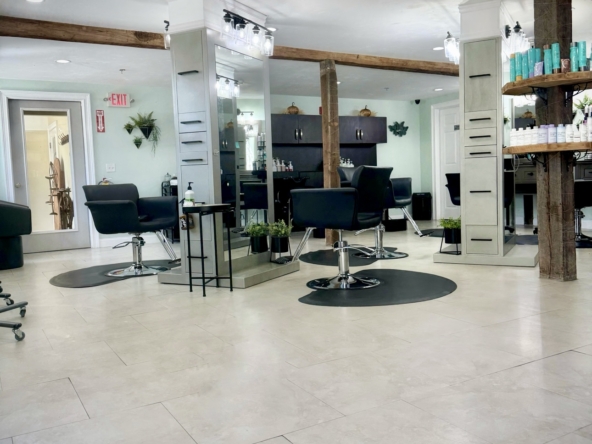 Bright, chic hair salon featuring professional styling areas and natural light.