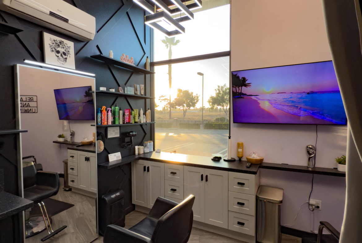 Contemporary salon space featuring sleek black and white finishes, stylish decor, and large natural light window.