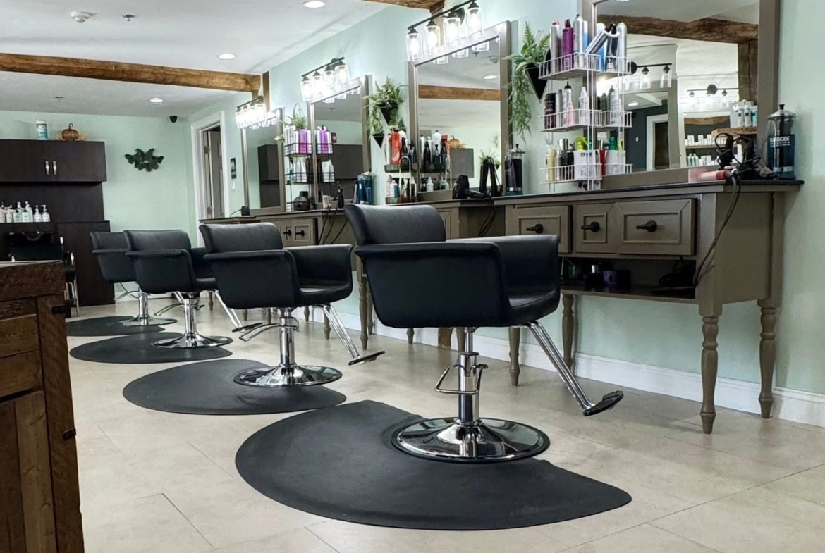 Bright salon interior with styling chairs, mirrors, and hair product shelves for professional hair services.