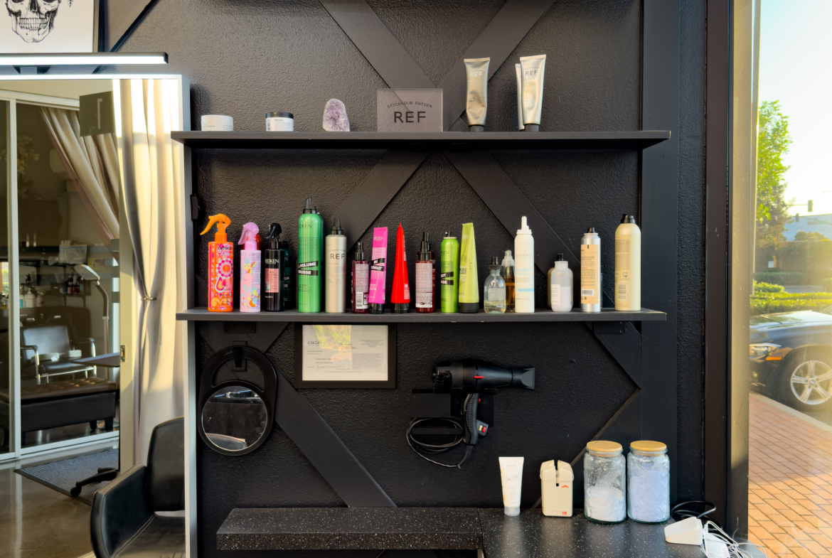 Detailed view of salon hair and beauty product shelf with styling tools.
