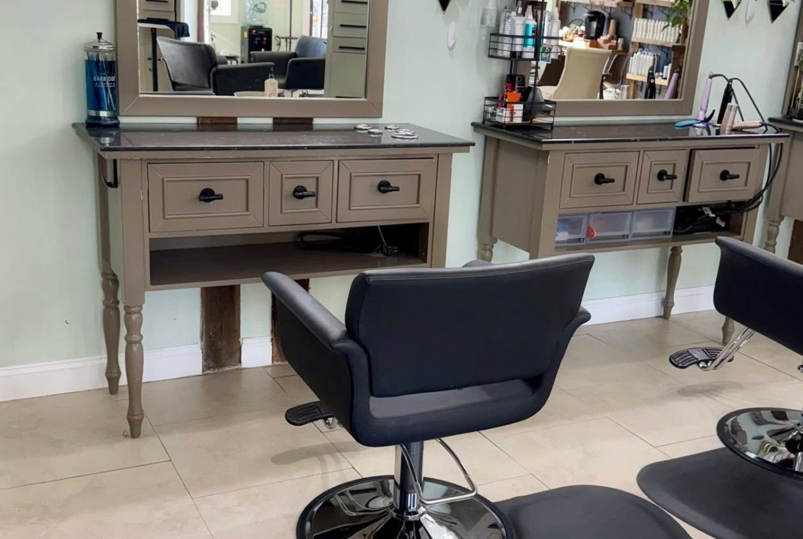 Stylish salon styling station with mirrors and chairs for haircuts. Perfect for professional salon environments.