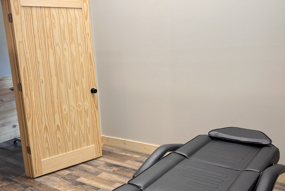 Comfortable massage table in a clean salon rental space, ideal for clients' relaxation.
