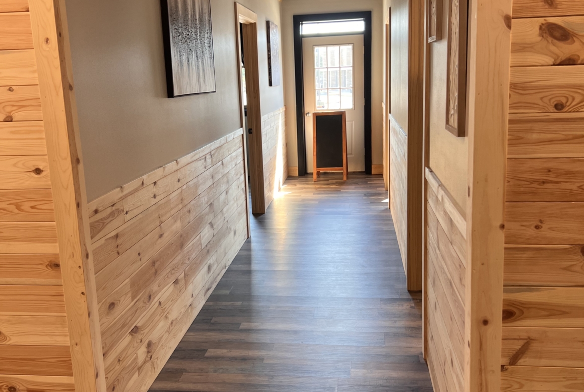 Bright, inviting interior hallway with wooden wall paneling and contemporary artwork.