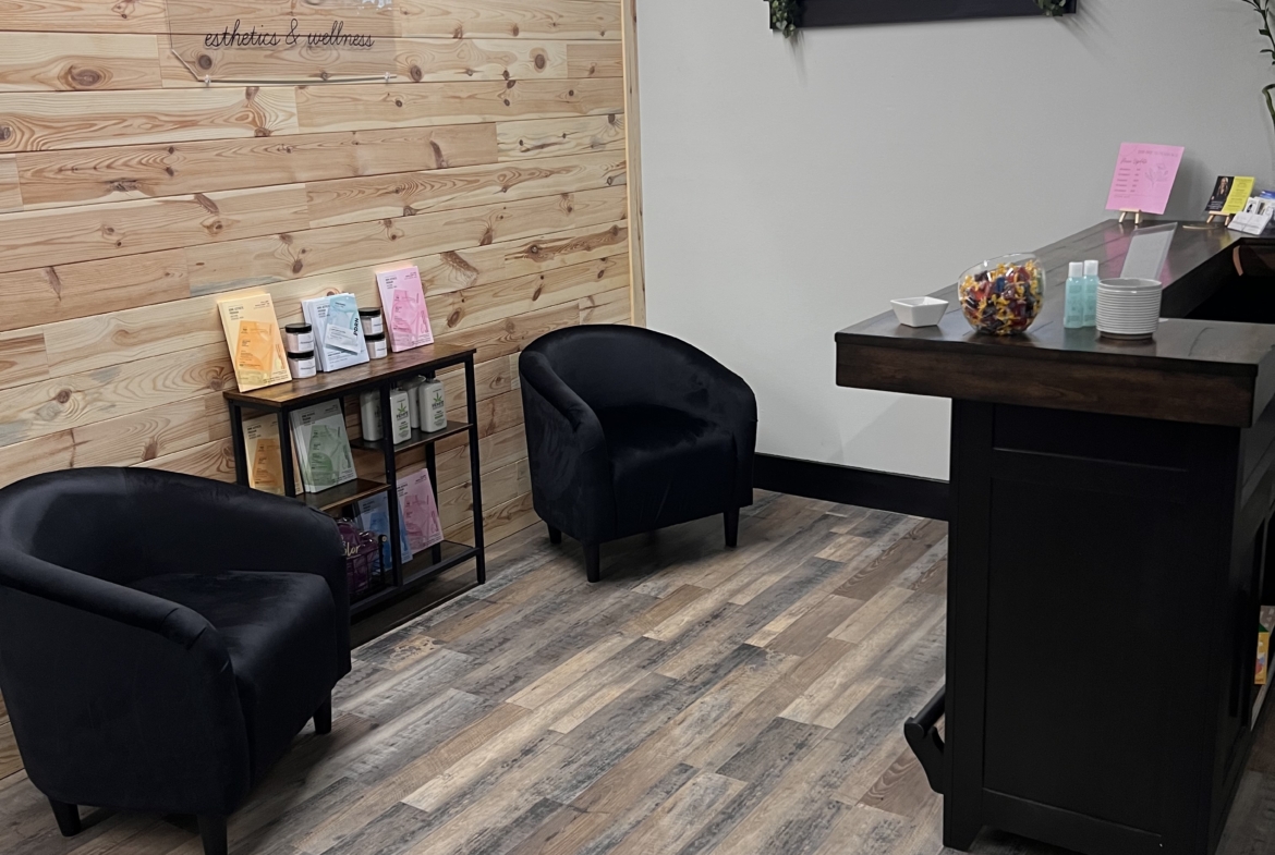 Comfortable black chairs and contemporary wooden accents in a serene salon lounge setting.