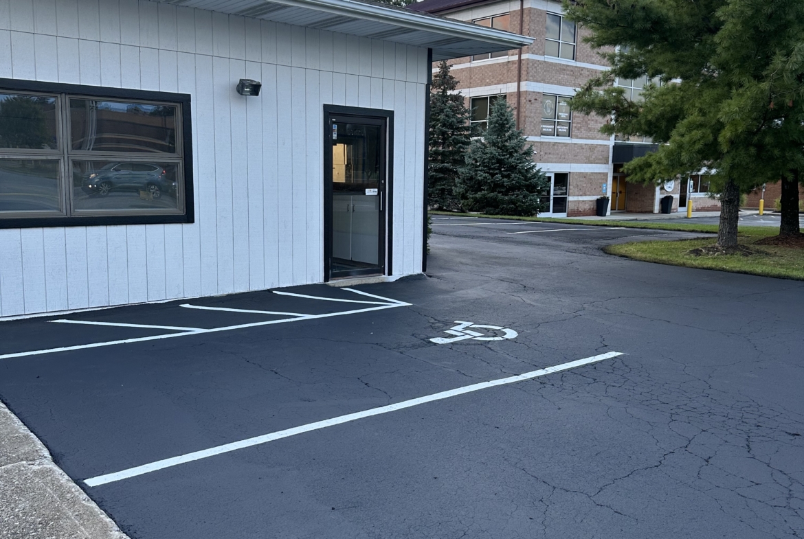 Accessible parking lot for salon renters with reserved space and storefront entrance.
